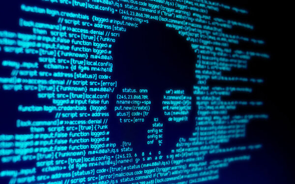 Auf einem Laptop ist sehr viel Code, der durch einen Totenkopf überdeckt wird