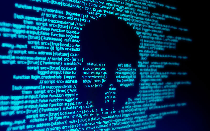 Auf einem Laptop ist sehr viel Code, der durch einen Totenkopf überdeckt wird