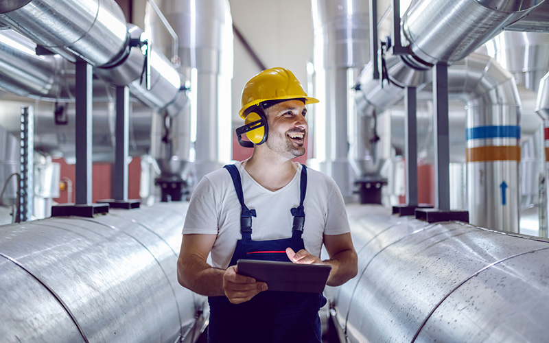 Man with tablet in hand has a yellow helmet on