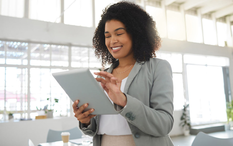 Frau hält Tablet in Hand und ist im Büro