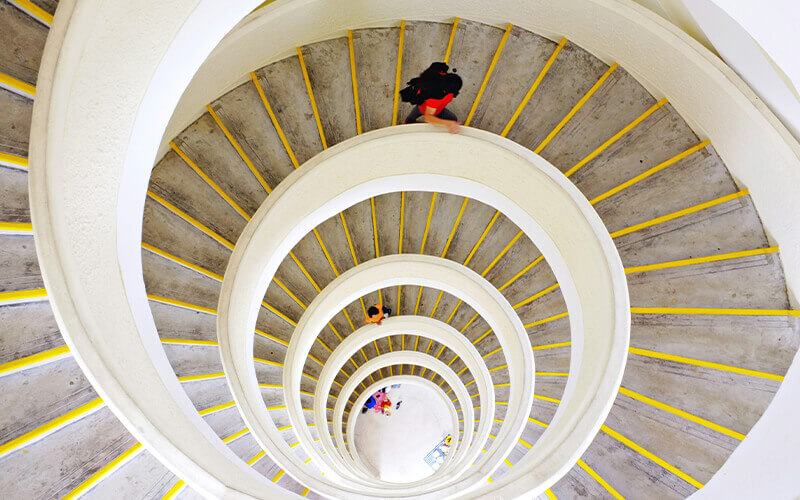 Personen gehen eine runde Treppe hinunter
