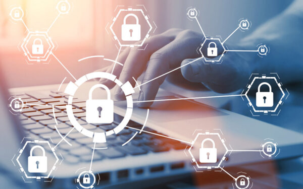 Person tippt auf einem Laptop, während digitale Symbole von Vorhängeschlössern eingeblendet sind, die Netzwerksicherheit und Datenschutz darstellen