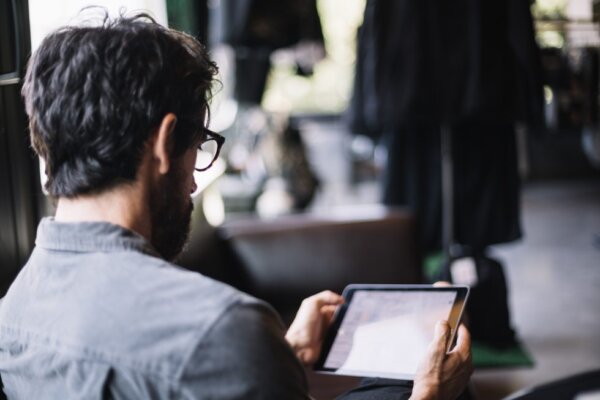 Mann hält ein Tablet in der Hand